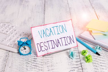 Word writing text Vacation Destination. Business photo showcasing a place where showing go for holiday or relaxation Notepaper stand on buffer wire in between computer keyboard and math sheets