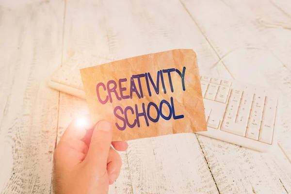 Writing note showing Creativity School. Business concept for students are able to use imagination and critical thinking Man holding colorful reminder square shaped paper wood floor