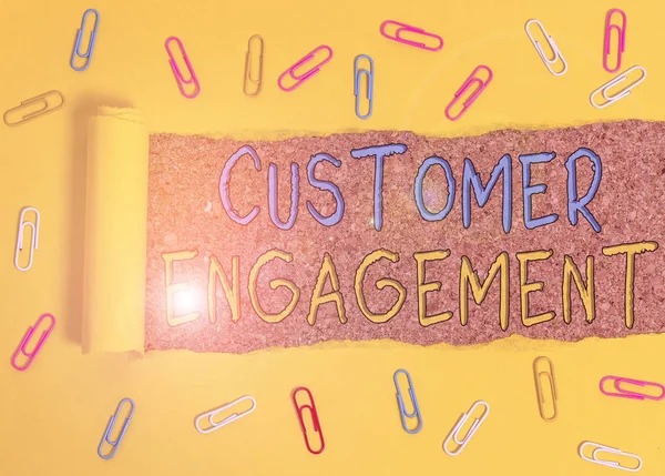 Text sign showing Customer Engagement. Business photo text the emotional connection between a customer and a brand Paper clip and torn cardboard placed above a wooden classic table backdrop