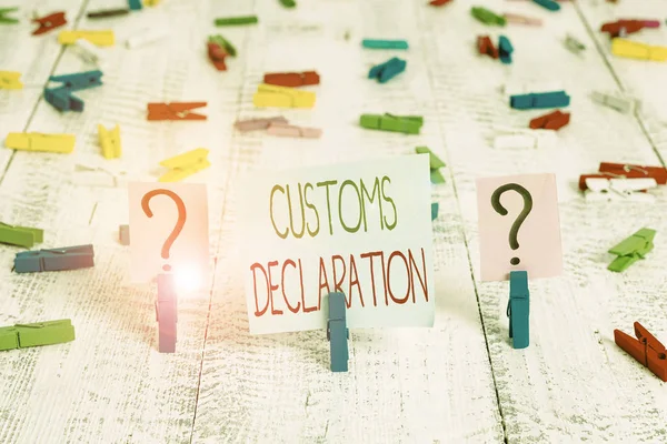 Text sign showing Customs Declaration. Business photo showcasing Official document showing goods being imported Scribbled and crumbling sheet with paper clips placed on the wooden table