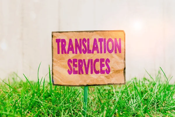 手書きのテキスト書き込み翻訳サービス スピーチを翻訳するための表示を提供する概念的な写真組織緑の芝生の土地に取り付けられ 配置された折り目のついた紙 — ストック写真