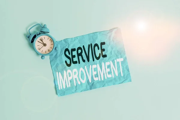 Conceptual hand writing showing Service Improvement. Concept meaning continuous actions that lead to better service or system Metal vintage alarm clock crush sheet sky colored background