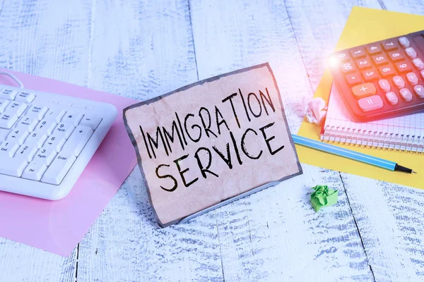 Text sign showing Immigration Service. Business photo showcasing responsible for law regarding immigrants and immigration Notepaper stand on buffer wire in between computer keyboard and math sheets