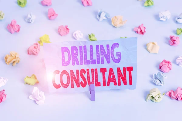 Word writing text Drilling Consultant. Business photo showcasing onsite supervision of daytoday drilling operations Colored crumpled papers empty reminder blue floor background clothespin