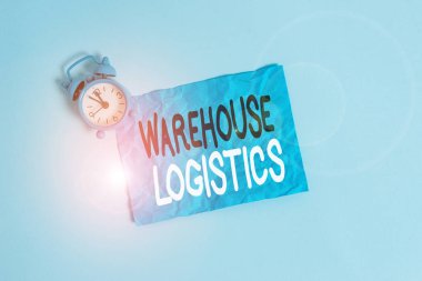 Conceptual hand writing showing Warehouse Logistics. Concept meaning flow of both physical goods and information in business Metal vintage alarm clock crush sheet sky colored background