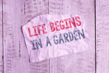 Text sign showing Life Begins In A Garden. Business photo showcasing Agriculture Plants growing loving for gardening Crumpled torn paper half broken placed above classic wooden background