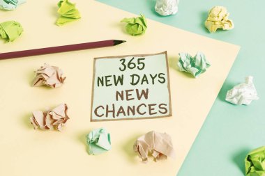 Kelime yazma metni 365 Yeni Gün Yeni Şanslar. Bir yıl daha Başlamak için iş konsepti Takvim Fırsatları Renkli buruşmuş kağıtlar boş mavi arka plan çamaşır mandalı.