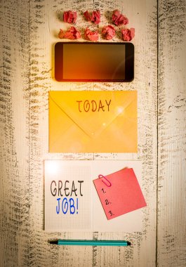 El yazısı harika bir iş. Birisine iyi bir şey yaptığını söyleyen kavramsal fotoğraf. Çevreleyen akıllı telefon not defteri. İşaretli kağıt toplar tahta arka plan.