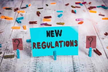 Yeni Yönetmelik Sorusu 'nu gösteren metin işareti. İş fotoğraflarının sergilenmesi devlet düzenini kontrol altına aldı. Bir şeyler yapıldı. Tahta masaya raptiyeler kondu.