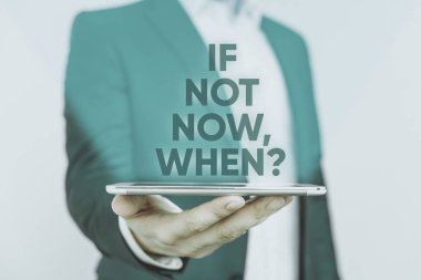 Soru Sorulduğunda Şimdi Değil 'i gösteren bir not yazıyorum. Şu andan itibaren harekete geçmek için iş konsepti: Mavi süitteki adam ve beyaz gömlek elinde cep telefonu tutmakta tereddüt etmeyin.