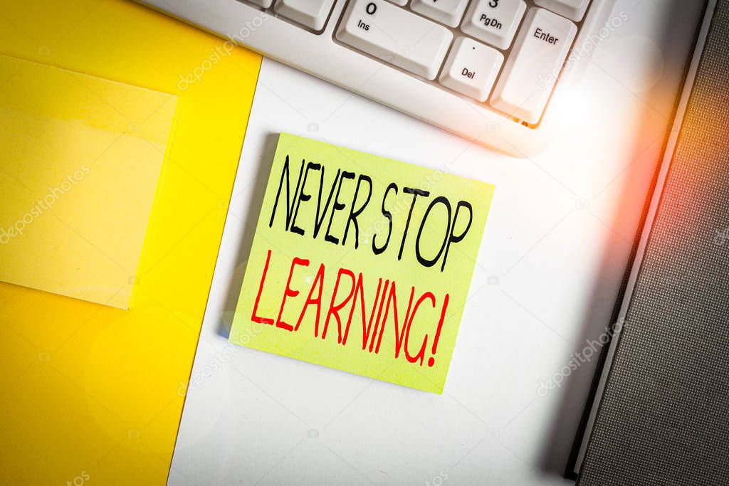 Text sign showing Never Stop Learning. Business photo showcasing keep on studying gaining new knowledge or materials Empty blank paper with copy space and pc keyboard above orange background table