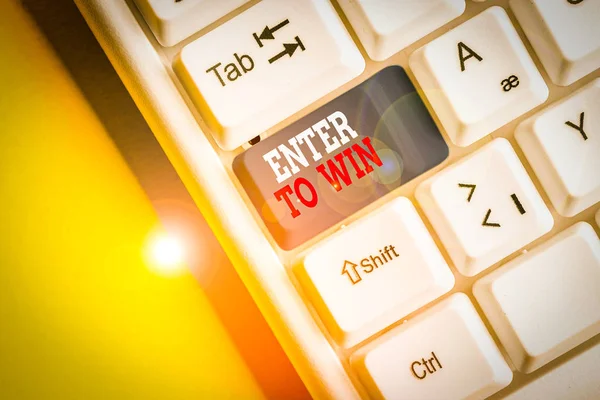 Writing note showing Enter To Win. Business concept for exchanging something value for prize or chance of winning White pc keyboard with note paper above the white background