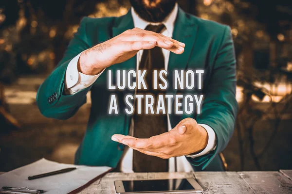 Conceptual hand writing showing Luck Is Not A Strategy. Concept meaning it is not being Lucky when planned intentionally Man in front of table. Mobile phone and notes on the table