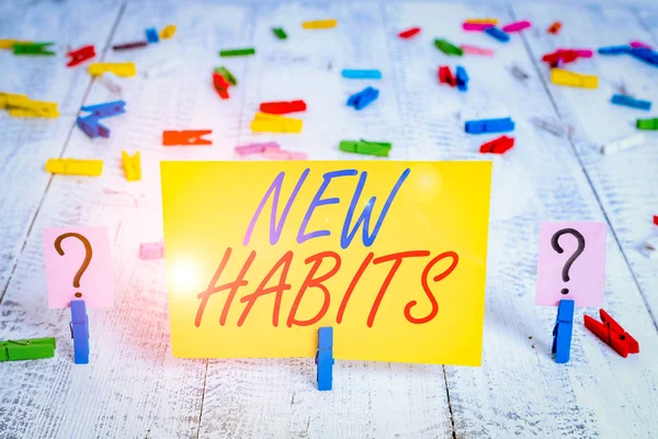 Yeni Alışkanlıkları gösteren not yazılıyor. İş konsepti, ahşap masaya tutturulmuş raptiyelerle düzenli olarak tekrar eden davranış rutinini değiştirmek.