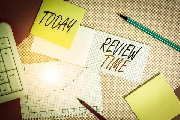 İnceleme Saati 'ni gösteren not yazılıyor. Bir şey hakkında tekrar düşünmek ya da konuşmak için iş konsepti Renkli düz masa üzerine yerleştirilen yazma donanımı ve bilgisayar şeylerini gözden geçirmek için takvimi ayarla