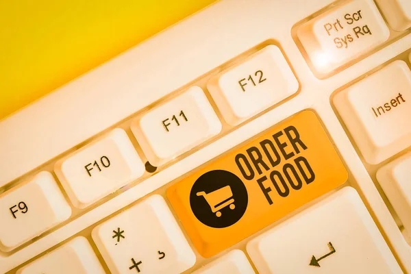 Conceptual hand writing showing Order Food. Concept meaning the process of requesting a preferred food in a restaurant White pc keyboard with note paper above the white background