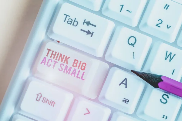 Handwriting text Think Big Act Small. Conceptual photo Great Ambitious Goals Take Little Steps one at a time White pc keyboard with empty note paper above white background key copy space