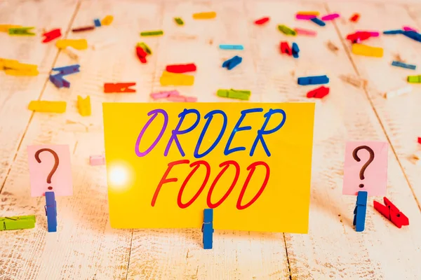 Writing note showing Order Food. Business concept for the process of requesting a preferred food in a restaurant Crumbling sheet with paper clips placed on the wooden table