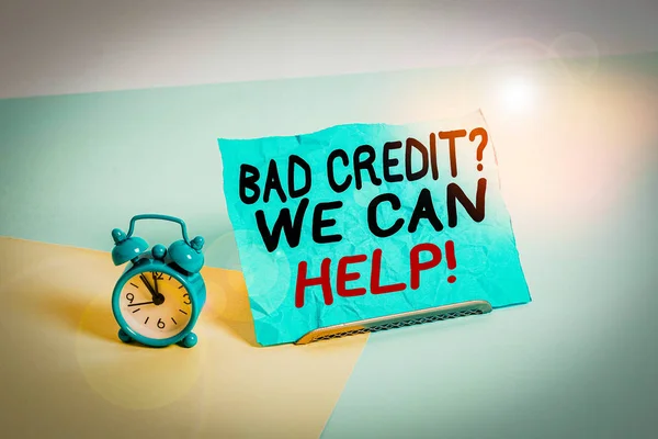 Writing note showing Bad Credit Question We Can Help. Business concept for offering help after going for loan then rejected Alarm clock beside a Paper sheet placed on pastel backdrop