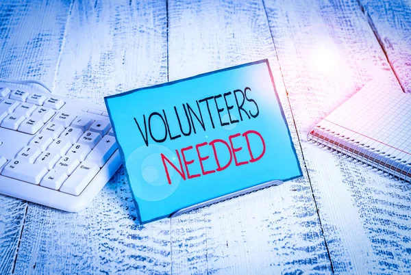 Writing note showing Volunteers Needed. Business concept for need work or help for organization without being paid Notepaper on wire in between computer keyboard and sheets