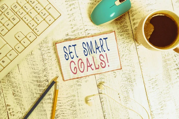 Handwriting text Set Smart Goals. Conceptual photo list to clarify your ideas focus efforts use time wisely technological devices colored reminder paper office supplies keyboard mouse