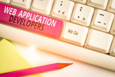 Web Uygulama Geliştiricilerini gösteren kavramsal el yazısı. Kavram, internet programlama uzmanları demek Teknoloji yazılımı Beyaz pc klavye beyaz arkaplan üzerinde not kağıdı ile