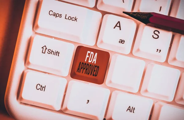 Handwriting text Fda Approved. Conceptual photo FDA agreed the product or formula is safe and or effective White pc keyboard with empty note paper above white background key copy space