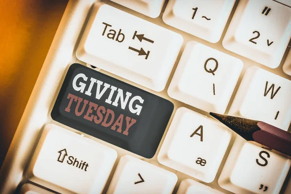 Writing note showing Giving Tuesday. Business concept for international day of charitable giving Hashtag activism White pc keyboard with note paper above the white background