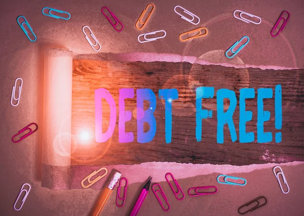 Writing note showing Debt Free. Business concept for does not owning any money to any individual or companies Stationary and torn cardboard on a wooden classic table backdrop