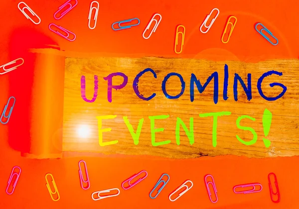 Text sign showing Upcoming Events. Business photo text thing that will happens or takes place soon planned occasion Paper clip and torn cardboard placed above a wooden classic table backdrop