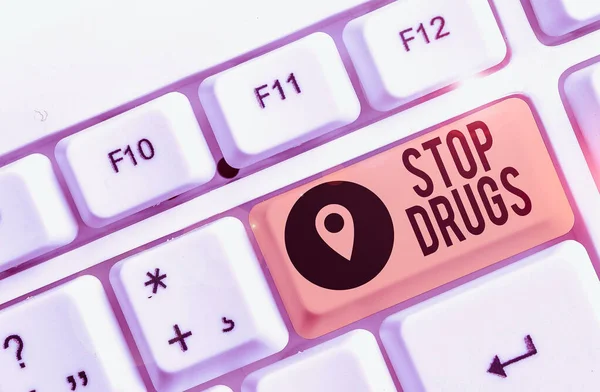 Conceptual hand writing showing Stop Drugs. Concept meaning put an end on dependence on substances such as heroin or cocaine White pc keyboard with note paper above the white background
