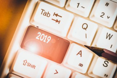 2019 İnceleme gösteren not yazma. 2019 beyaz arka plan üzerinde not kağıdı ile 2019 Beyaz pc klavye için turizm veya hizmetlerde yeni trendler ve beklentiler için iş konsepti