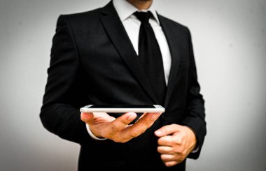 Erkek insan resmi iş kıyafeti giyer. Akıllı teknoloji akıllı telefonu kullan. Bir elini kullan.