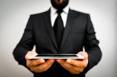 Erkek insan resmi iş kıyafeti giyer. Akıllı teknoloji akıllı telefon kullan.