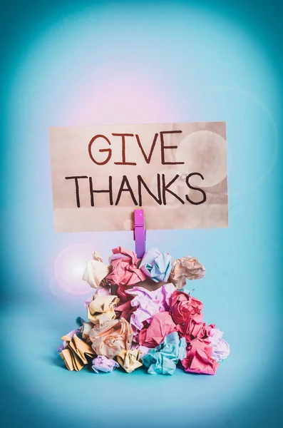 Word writing text Give Thanks. Business photo showcasing express gratitude or show appreciation Acknowledge the kindness Reminder pile colored crumpled paper clothespin reminder blue background