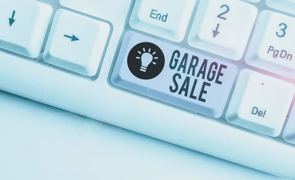 Text sign showing Garage Sale. Business photo showcasing sale of miscellaneous household goods often held in the garage White pc keyboard with empty note paper above white background key copy space