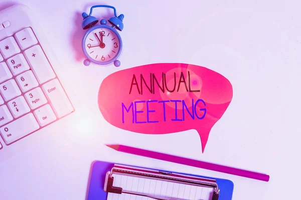 Word writing text Annual Meeting. Business photo showcasing yearly meeting of the general membership of an organization Flat lay above table with clock pc keyboard and copy space note paper