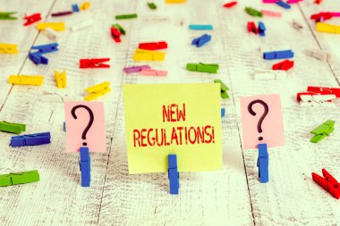 Yeni Yönetmelikleri gösteren not yazılıyor. Kurallar için iş kavramı hükümetin düzeni kontrol altına almasını sağladı. Tahta masaya raptiyeyle tutturulmuş bir şey.