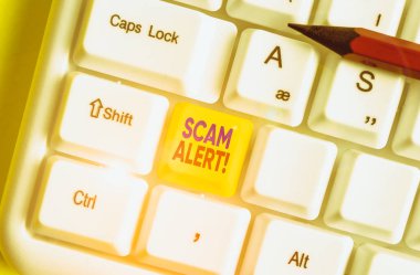 Scam Alert 'i gösteren not yazılıyor. Dolandırıcılık konsepti, kurbandan para kazanmak için onu ikna etmek.