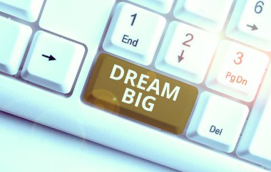 Dream Big 'i gösteren bir not yazıyorum. Hayatınız için bir amaç arama ve işlemde Beyaz PC klavye ile yerine getirilmek için iş konsepti beyaz arkaplan üzerinde not kağıt