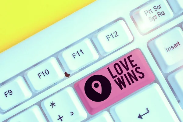 Writing note showing Love Wins. Business concept for used to celebrate or commemorate the victory of marriage equality White pc keyboard with note paper above the white background