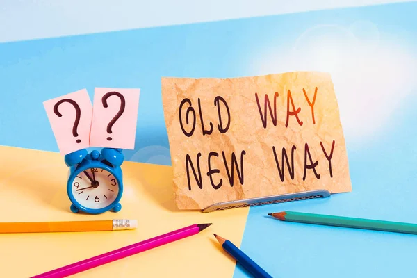 Conceptual hand writing showing Old Way New Way. Concept meaning The different way to fulfill the desired purposes Mini size alarm clock beside stationary on pastel backdrop