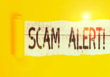Text sign showing Scam Alert. Business photo text fraudulently obtain money from victim by persuading him Cardboard which is torn in the middle placed above a wooden classic table clipart