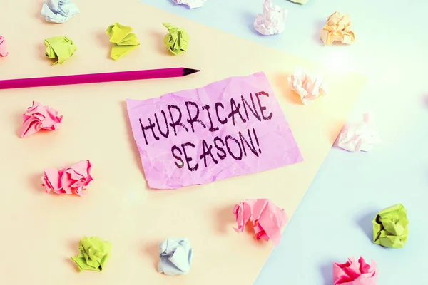 Writing note showing Hurricane Season. Business concept for time when most tropical cyclones are expected to develop Colored crumpled papers empty reminder blue yellow clothespin
