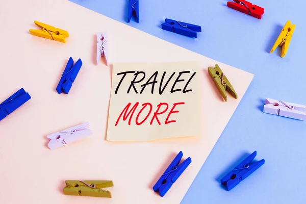 Word writing text Travel More. Business photo showcasing To make a journey often especially on long distance trip Colored clothespin paper empty reminder yellow blue floor background office