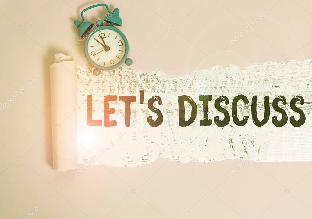 Text sign showing Let S Discuss. Conceptual photo asking someone to talk about something with demonstrating or showing Alarm clock and torn cardboard placed above a wooden classic table backdrop.