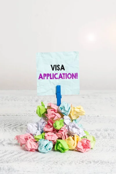 Handwriting text Visa Application. Conceptual photo Form to ask permission travel or live in another country Reminder pile colored crumpled paper clothespin reminder white wooden space