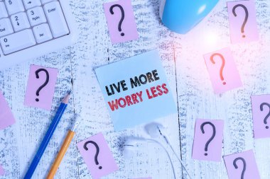 Daha Az Endişeli Yaşa 'yı gösteren kavramsal el yazısı. Kavram demek iyi bir tutum motivasyonu olmak dikkatsiz olmak hayatın tadını çıkarmak araçlar yazmak ve ahşap masanın üstüne karalanmış kağıt