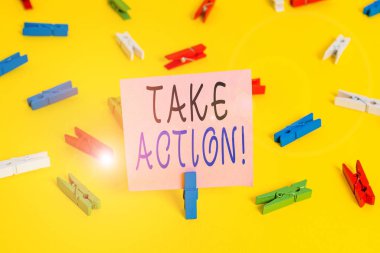 Harekete Geçildiğini gösteren metin işareti. İş fotoğrafçılığı resmi bir şey yap ya da sorunlu bir hedefe ulaşmak için uyumlu bir şey yap Renkli çamaşır iğnesi kağıtları boş hatırlatıcı sarı zemin arka plan ofisi