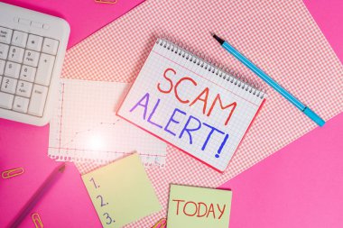 El yazısı mesaj dolandırıcılığı alarmı. Kavramsal fotoğraf sahte bir şekilde kurbandan para alıyor. Renkli düz masa üzerine yerleştirilmiş bilgisayar malzemelerini ve yazı malzemelerini onu ikna ederek.